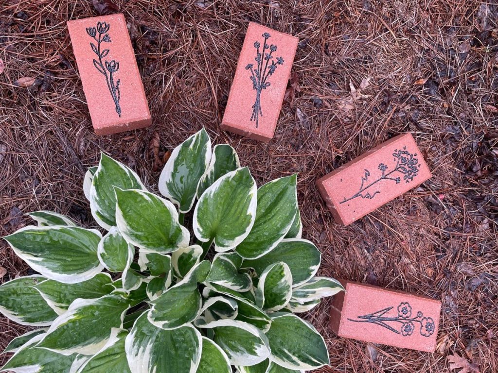 Flowers engraved on clay pavers and hand-painted black