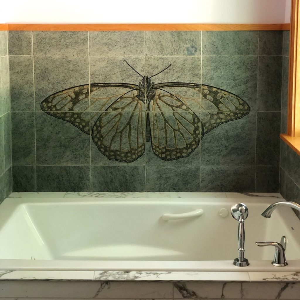 Engraved monarch butterfly engraved and hand painted on green granite tiles.