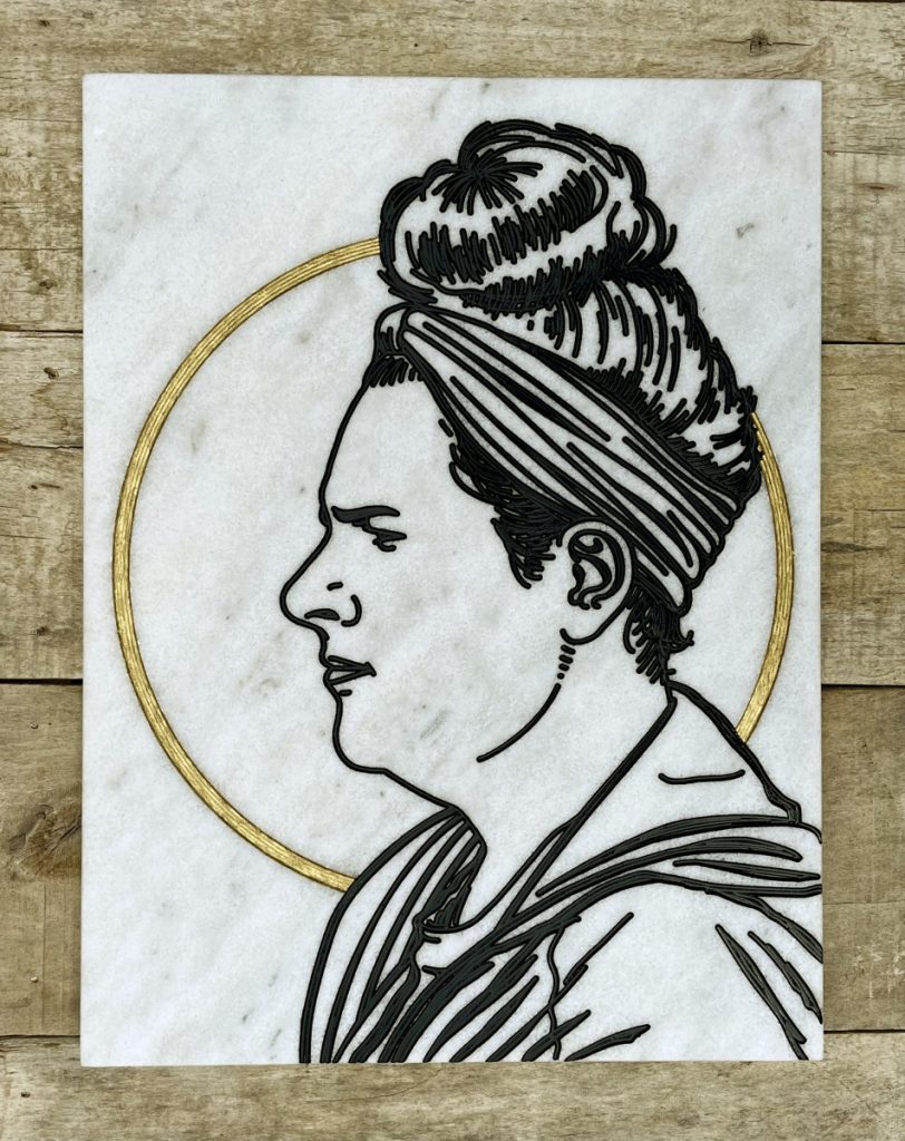 Profile portrait engraved on white marble and hand painted black and gold.