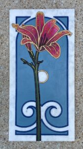 Marble tile with a lily set in Art Deco background engraved and painted on it.