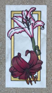 Marble tile with two types of lilies in a gold frame engraved and painted on it.