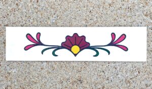 Marble tile with stylized design engraved and painted on it.