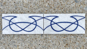 4in. x 8in. engraved white marble tiles aligned in a pattern White marble tiles with identical design placed side by side to display a pattern