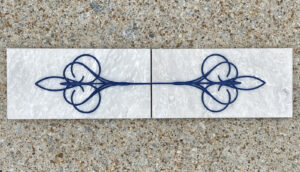 4in. x 8in. engraved white marble tiles aligned in a pattern White marble tiles with identical design placed side by side to display a pattern.