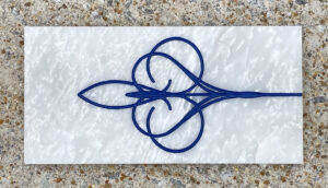 4in. x 8in. engraved white marble tile, blue lacquer White marble tile with a design engraved and painted in blue on it.